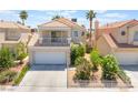 Attractive two-story home featuring a balcony, two-car garage, complemented by lush landscaping and mature palm trees at 2452 Silver Shadow Dr, Las Vegas, NV 89108