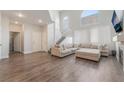 Spacious living room with high ceilings, modern flooring, and a comfortable sectional sofa, perfect for relaxation at 2452 Silver Shadow Dr, Las Vegas, NV 89108