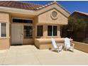 Inviting front of home featuring a cozy sitting area with two white Adirondack chairs at 2505 Showcase Dr, Las Vegas, NV 89134