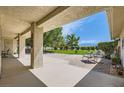 Spacious covered patio with brick accents and a peaceful view of the lush green lawn and distant mountains at 3231 Rebel Ave, Pahrump, NV 89048