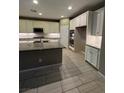 Bright kitchen with a large island, stainless appliances, and stylish tile flooring at 4108 Fairywren Dr, North Las Vegas, NV 89031