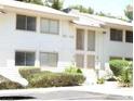 Clean exterior of a two-story unit featuring white siding, a small front yard with mature shrubs, and dual entry doors at 4770 Topaz St # 113, Las Vegas, NV 89121