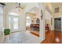 Home foyer and dining area featuring a tiled entry, chandelier, arched doorways, and hardwood floors at 6841 Longmeadow Dr, Pahrump, NV 89061