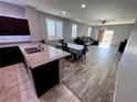 Bright kitchen featuring a large island, dark wood cabinets, and a view to the living area at 7035 Thistle Ridge St, Las Vegas, NV 89166