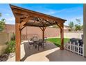 This outdoor gazebo features a corrugated metal roof, timber framing, and space for a table and chairs at 8015 Maple Park St, Las Vegas, NV 89131
