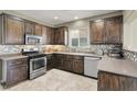 A kitchen with dark cabinets, stainless steel appliances, mosaic backsplash, and neutral countertops at 8015 Maple Park St, Las Vegas, NV 89131