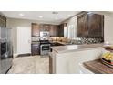 Kitchen with wooden cabinets, stainless steel appliances, and breakfast bar at 8015 Maple Park St, Las Vegas, NV 89131