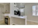 An open kitchen with a breakfast bar, and a stylish fireplace nearby at 9050 W Warm Springs Rd # 1117, Las Vegas, NV 89148