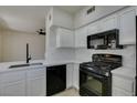 Bright kitchen with sleek countertops, white cabinetry, and modern black appliances at 9050 W Warm Springs Rd # 1117, Las Vegas, NV 89148