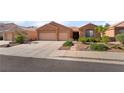 Charming single-story home with a three-car garage, desert landscaping, and neutral color palette at 940 Rifle Dr, Henderson, NV 89002