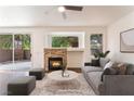 Cozy living room with a stone fireplace, modern decor, and sliding glass door at 10505 Jeremy Ridge Ave, Las Vegas, NV 89144