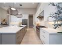 Modern kitchen featuring a large island, stainless steel appliances, and designer lighting at 10781 Agate Cliffs Ave, Las Vegas, NV 89135