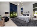 Serene main bedroom with large windows offering natural light and views of the landscaped yard at 10781 Agate Cliffs Ave, Las Vegas, NV 89135