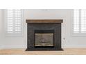 Close-up of marble fireplace with wood mantle, flanked by shuttered windows at 1515 Horizon Crest Ct, Henderson, NV 89012