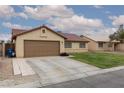 Charming single-story house featuring a red tile roof, a well-manicured lawn, and an attached two car garage at 1835 Banaba Ln, Las Vegas, NV 89156