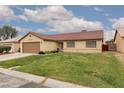 Charming single-story house featuring a red tile roof, a well-manicured lawn, and an attached two car garage at 1835 Banaba Ln, Las Vegas, NV 89156