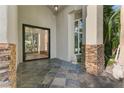 Elegant front entrance with stone accents and a modern glass door leading into the home's foyer at 2309 Prometheus Ct, Henderson, NV 89074