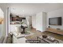 Inviting living room with wood floors flows into kitchen with stainless appliances at 2773 Green Envy Ave # 245, North Las Vegas, NV 89086