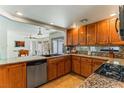 Well-lit kitchen featuring wood cabinetry, granite countertops, and modern appliances at 2829 Via Florentine St, Henderson, NV 89074