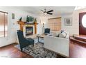 Comfortable living room with fireplace, wood floors, ceiling fan and large windows at 2829 Via Florentine St, Henderson, NV 89074