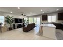 Open-concept living room featuring tile floors, a ceiling fan, and sliding glass doors at 2924 Sunday Silence Rd, North Las Vegas, NV 89086