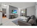 Cozy living room features a comfortable sofa, a modern TV, and sliding glass doors to a balcony at 4200 S Valley View Blvd # 1007, Las Vegas, NV 89103