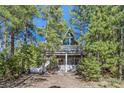 A-frame home with a large window and balcony nestled among tall trees at 5230 Whispering Robin Ln, Mount Charleston, NV 89124