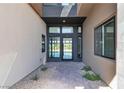 Contemporary home entrance featuring a glass door, stone walkway, and desert landscaping at 5364 Succulent Rose Dr, Las Vegas, NV 89135