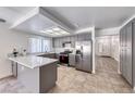 Modern kitchen with stainless steel appliances, grey cabinetry, tile floor, and breakfast bar at 5639 Guiding Star Cir, North Las Vegas, NV 89031