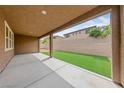 Covered patio with concrete flooring overlooks the low maintenance backyard with artificial grass at 705 Coastal Lagoon St, Henderson, NV 89002