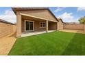 Backyard featuring artificial grass, gravel, and a covered patio at 705 Coastal Lagoon St, Henderson, NV 89002