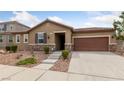 Charming single-story home featuring a stone veneer, desert landscaping, and a two-car garage at 705 Coastal Lagoon St, Henderson, NV 89002