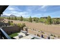Private backyard with lush landscaping, a modern built-in barbeque, and mountain views at 754 Agate Hills St, Las Vegas, NV 89138