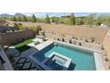Backyard oasis featuring a modern pool, attached hot tub, built-in grill and lush landscaping at 754 Agate Hills St, Las Vegas, NV 89138