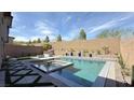 A sparkling modern pool with attached hot tub, built-in grill, and low-maintenance backyard at 754 Agate Hills St, Las Vegas, NV 89138
