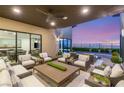 Elegant outdoor patio with comfortable seating, ceiling fan, and stunning sunset views over the city at 826 Bolide St, Las Vegas, NV 89138