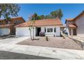 Quaint single-story home showcases desert landscaping, red tile roof, and a two car garage at 8640 Trafalgar Dr, Las Vegas, NV 89117