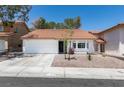 Charming single-story home features a red tile roof, white exterior paint, and a two car garage at 8640 Trafalgar Dr, Las Vegas, NV 89117