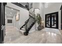 Elegant foyer with a curved staircase, soaring ceilings, modern chandelier, and marble flooring, creating a grand entrance at 9 Clear Crossing Trl, Henderson, NV 89052