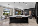 Open-concept kitchen featuring a large island, stainless steel appliances, modern lighting, and seamless flow to dining and living areas at 9 Clear Crossing Trl, Henderson, NV 89052