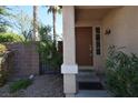 Close-up of a home's front entrance with a decorative door and lush landscaping at 1220 Padre Serra Ln, Las Vegas, NV 89134