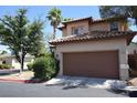 Two-story home featuring a large garage, desert landscaping, and a tile roof in a residential area at 1220 Padre Serra Ln, Las Vegas, NV 89134