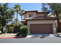 Two-story home featuring a large garage, desert landscaping, and a tile roof in a residential area at 1220 Padre Serra Ln, Las Vegas, NV 89134