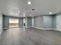 Spacious living room with new gray vinyl flooring, recessed lighting, and a sliding glass door at 1509 Linnbaker Ln # 102, Las Vegas, NV 89110