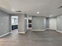 Bright living room with gray vinyl flooring and a view to the kitchen with stainless steel appliances at 1509 Linnbaker Ln # 102, Las Vegas, NV 89110