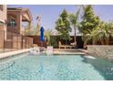 Relaxing backyard pool area features a soothing waterfall, mature trees, and a comfortable lounging space at 2750 Evolutionary Ln, Las Vegas, NV 89138
