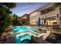 Beautiful pool area with a spa, lush landscaping, lounge chairs, and an outdoor living area at 2750 Evolutionary Ln, Las Vegas, NV 89138