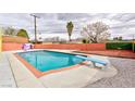 Backyard pool with a diving board surrounded by lush greenery and patio space at 3008 Lawndale St, Las Vegas, NV 89121