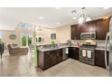 Modern kitchen with stainless steel appliances, granite countertops, and a cozy breakfast bar at 3159 Via Como, Henderson, NV 89044