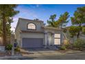 Two-story home with xeriscaping and a tile roof stands adjacent to a neighboring residence at 3481 Creek River Dr, Las Vegas, NV 89129